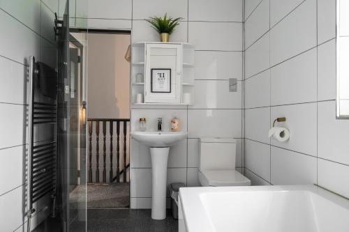 a bathroom with a sink and a toilet and a tub at Sun Street Cottage - with log burner, jet bath and Summerhouse in Haworth