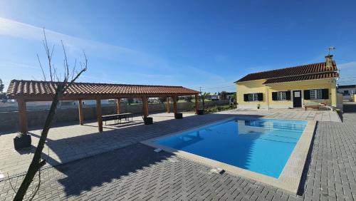 a swimming pool in front of a house at Quinta Marinhais para férias no Ribatejo in Marinhais