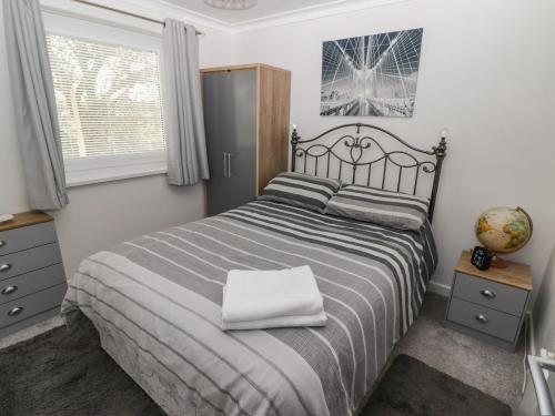 a bedroom with a bed with a white pillow on it at 13 Gower Holiday Village in Swansea