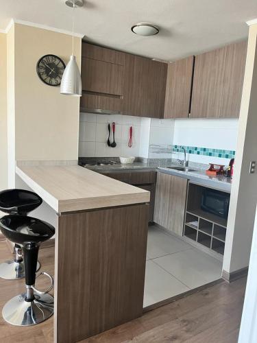a kitchen with wooden cabinets and a counter top at Edificio Concepto in Calama