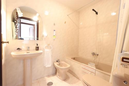 a bathroom with a sink and a toilet and a tub at Apartamento CASA VETONA in Béjar