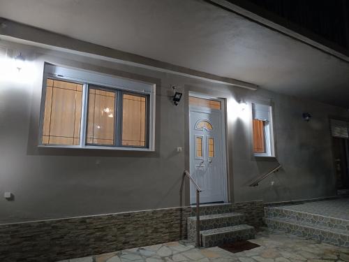 uma casa com uma porta branca e duas janelas em PS House Amfikleia - PS Rental em Amfikleia