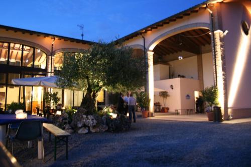 a building with tables and umbrellas in a courtyard at Agriturismo Argaland in Parma