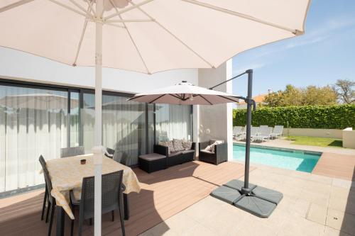 a patio with a table and an umbrella at Bela Vista da Luz 17 by Destination Algarve in Luz