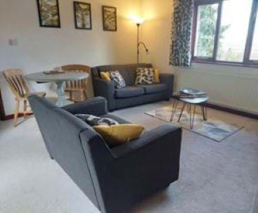 - un salon avec un canapé et une table dans l'établissement 2 bed barn with spectacular views - Wye Valley, à Symonds Yat