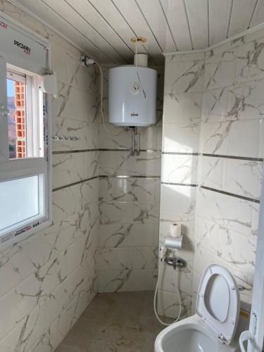 een witte badkamer met een toilet en een wastafel bij Vacancia in Douar Chaïb Rasso