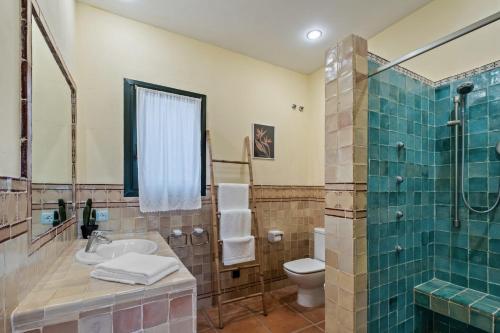 La salle de bains est pourvue d'un lavabo, de toilettes et d'une douche. dans l'établissement Villa Kahuna Sotogrande, à Sotogrande