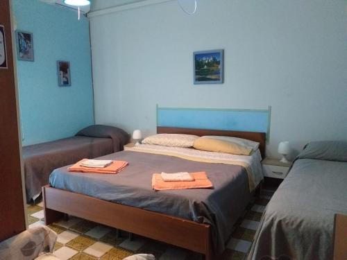 una camera con due letti e asciugamani di B&B Ai piedi dell'Etna ad Acireale