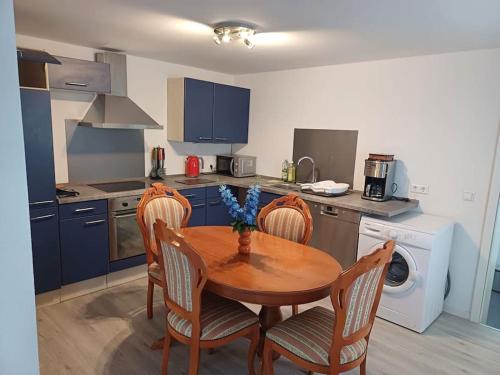 a kitchen with a wooden table and chairs and a kitchen with a washing machine at wie zu Hause in Ludwigsburg