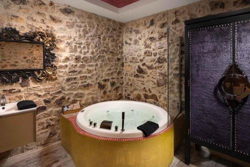 a bath tub in a bathroom with a stone wall at EL PALACETE SOÑADO o in La Roza