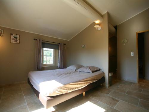 Schlafzimmer mit einem großen Bett und einem Fenster in der Unterkunft Le Mistral in Apt