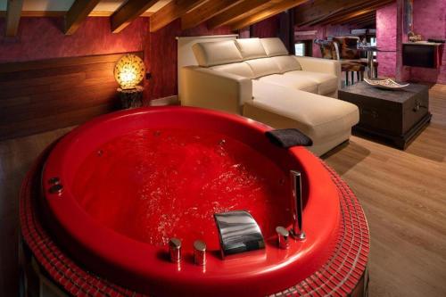 a red bath tub in a living room with a couch at EL PALACETE SOÑADO o in La Roza