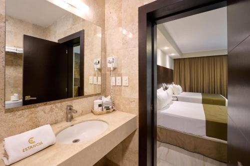 a bathroom with a sink and a bed at Hotel Estancia Business Class in Guadalajara
