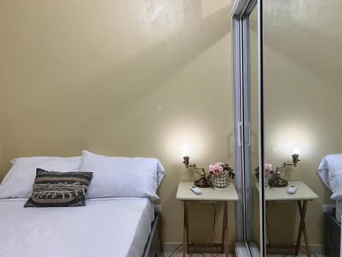a bedroom with a bed and two tables with flowers at J&W apartment in San Felipe de Puerto Plata