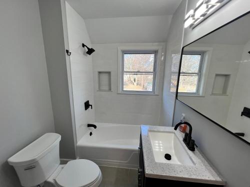a white bathroom with a toilet and a sink at Harvrd-MIT-B.U./Parkfree/Single Family residence in Boston