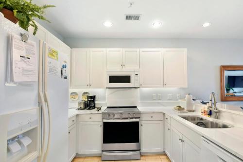 a white kitchen with a stove and a microwave at Windward Point 109 in Saint Simons Island