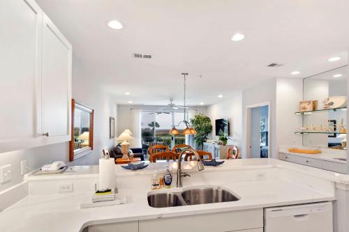 a kitchen with a sink and a living room at Windward Point 109 in Saint Simons Island