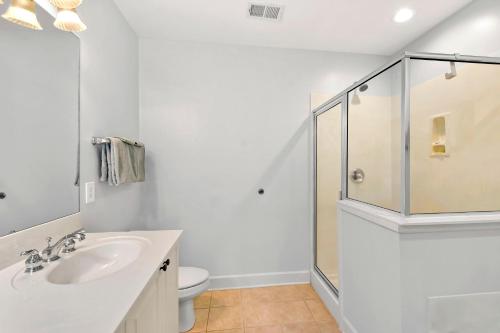 a white bathroom with a sink and a shower at Windward Point 109 in Saint Simons Island