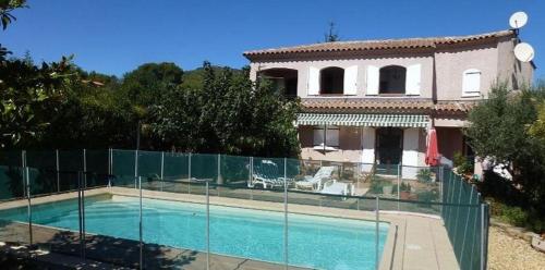 a house with a swimming pool in front of a fence at T2 rez de villa proche de la mer b&b sita in Saint-Cyr-sur-Mer