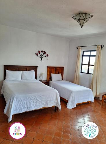 a bedroom with two beds and a window at Hotel Cielito Lindo, Taxco in Taxco de Alarcón