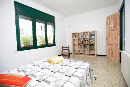um quarto com uma cama, uma janela e uma estante de livros em Apartamento céntrico en Sant Feliu de Guíxols em Sant Feliu de Guíxols