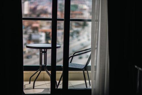 a table and a chair in front of a window at Destiny Hotel & SPA in Tirana