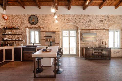 een grote keuken met een tafel in een kamer bij Wood and Stone Ηouse in Aegina Town