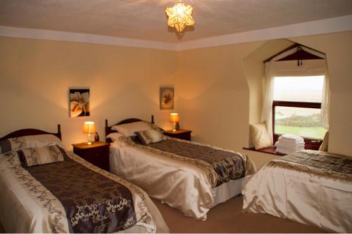a hotel room with two beds and a window at Duddon Villa in Millom