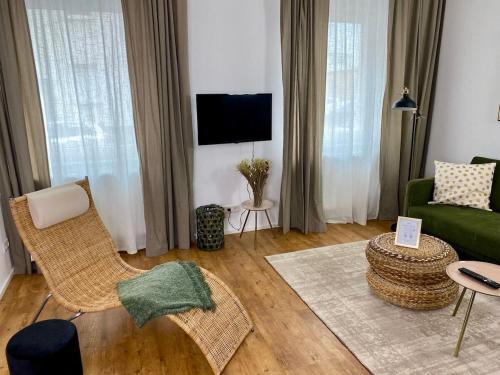 een woonkamer met een groene bank en stoelen bij discovAIR Eisenach - 3-Zi- Apartment Matteo- Schwimmbad-Nah mit Netflix in Eisenach