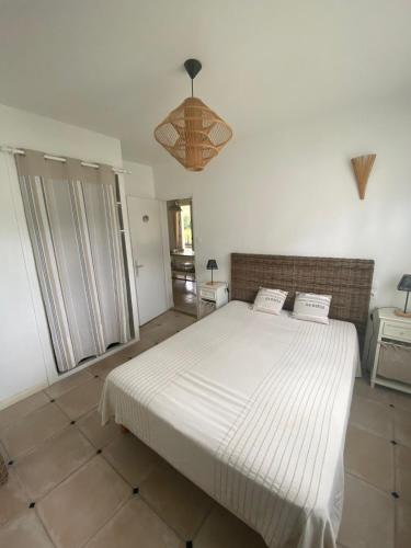 une chambre avec un grand lit blanc dans une pièce dans l'établissement Maison typique île de ré, à Rivedoux-Plage