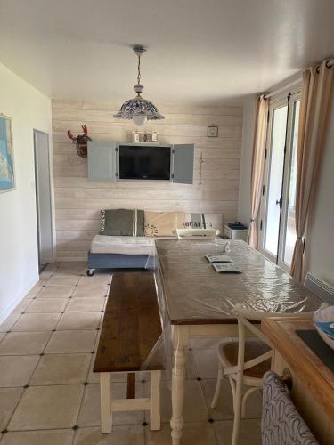 - une cuisine avec une table et un canapé dans une chambre dans l'établissement Maison typique île de ré, à Rivedoux-Plage