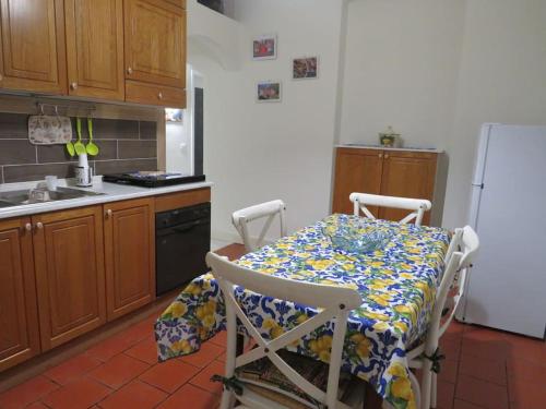 een keuken met een tafel en een koelkast bij Mosa House in Aci Castello