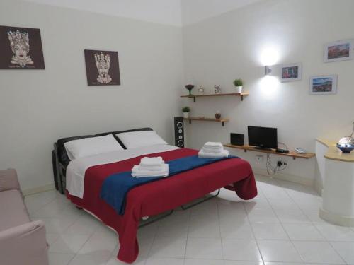 een slaapkamer met een bed met een rode en blauwe deken bij Mosa House in Aci Castello