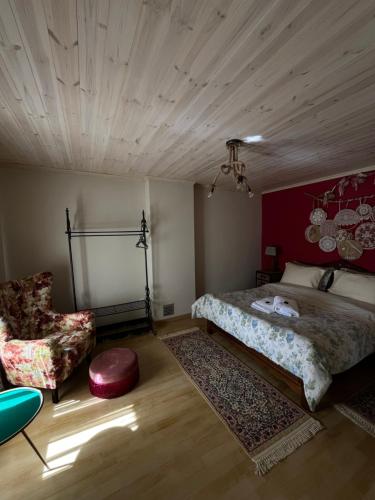 een slaapkamer met een bed en een stoel bij Petrameli in Karpenisi