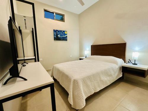 a bedroom with a large bed and a mirror at Villas Mar Turquesa Cozumel in Cozumel