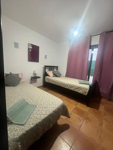 - 2 lits dans une chambre avec des rideaux violets dans l'établissement CASA SIBILA, à Playa Honda