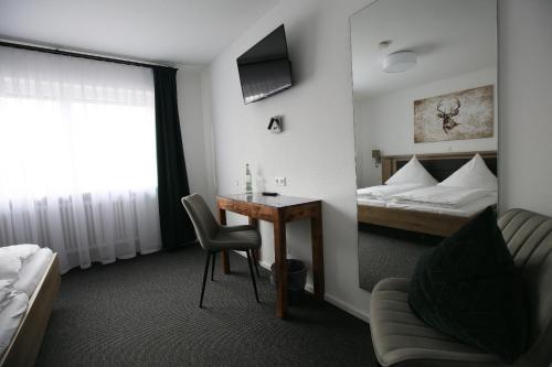 a hotel room with a desk and a bed at Landgasthof Schützen in Tengen