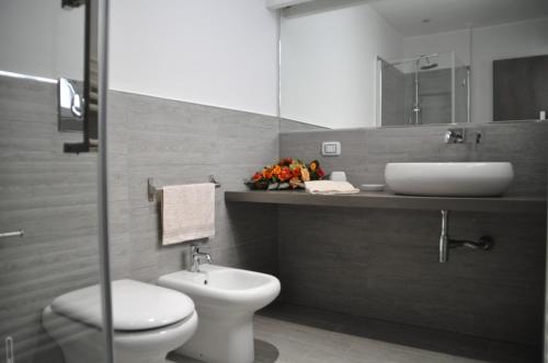 uma casa de banho com um lavatório, um WC e um espelho. em Al Bastione Holiday House em Palermo