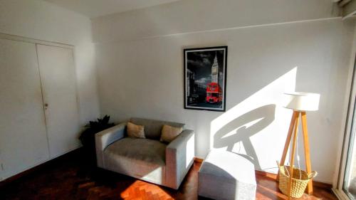 a living room with a chair and a picture on the wall at Hermoso Departamento con Balcón Obelisco II in Buenos Aires