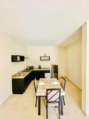 a dining room with a table and a kitchen at Villas Mar Turquesa Cozumel in Cozumel