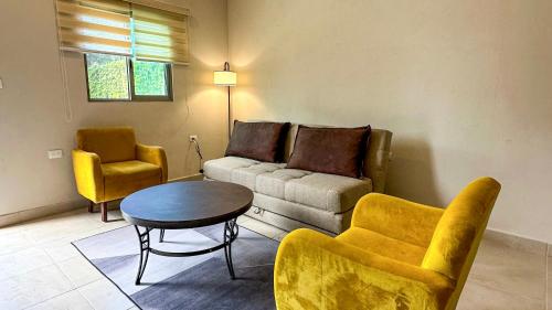 a living room with a couch and a table and chairs at Villas Mar Turquesa Cozumel in Cozumel