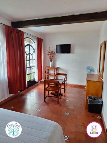a living room with a couch and a table and a chair at Hotel Cielito Lindo, Taxco in Taxco de Alarcón