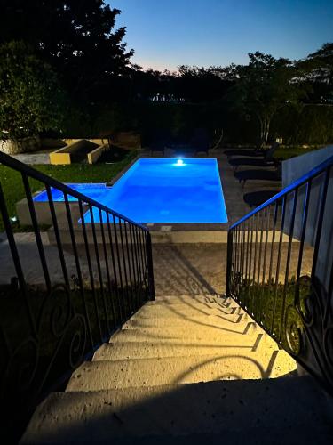 a blue swimming pool in a yard at night at Villas Mar Turquesa Cozumel in Cozumel