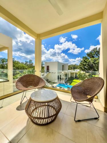 two chairs and a table on a patio with a view at Villas Mar Turquesa Cozumel in Cozumel