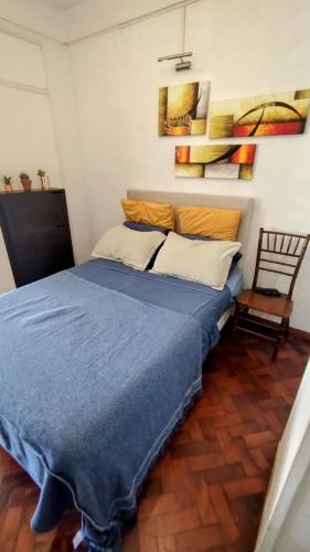 a bedroom with a blue bed and a chair at Hermoso Departamento con Balcón Obelisco II in Buenos Aires