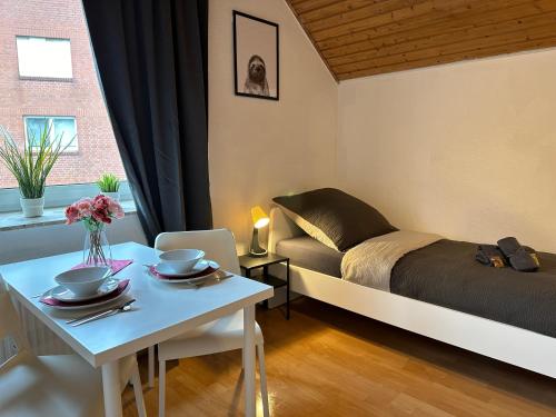 um pequeno quarto com uma cama e uma mesa com uma mesa de sidx em 3-Zimmer Apartment für Monteure & Geschäftsreisende: Schnelles Internet em Stemshorn