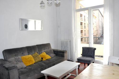 un salon avec un canapé et une chaise dans l'établissement Bright apartment close to city centre, à Marseille