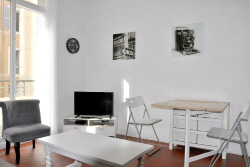 un salon avec une télévision, une table et des chaises dans l'établissement Bright apartment close to city centre, à Marseille