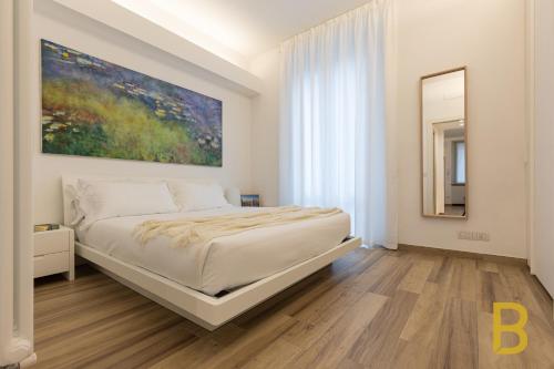 een slaapkamer met een bed en een schilderij aan de muur bij BePlace Apartments in Gioia in Milaan