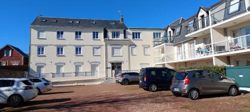 un groupe de voitures garées devant un bâtiment dans l'établissement Les Marronniers 30, à Berck-sur-Mer